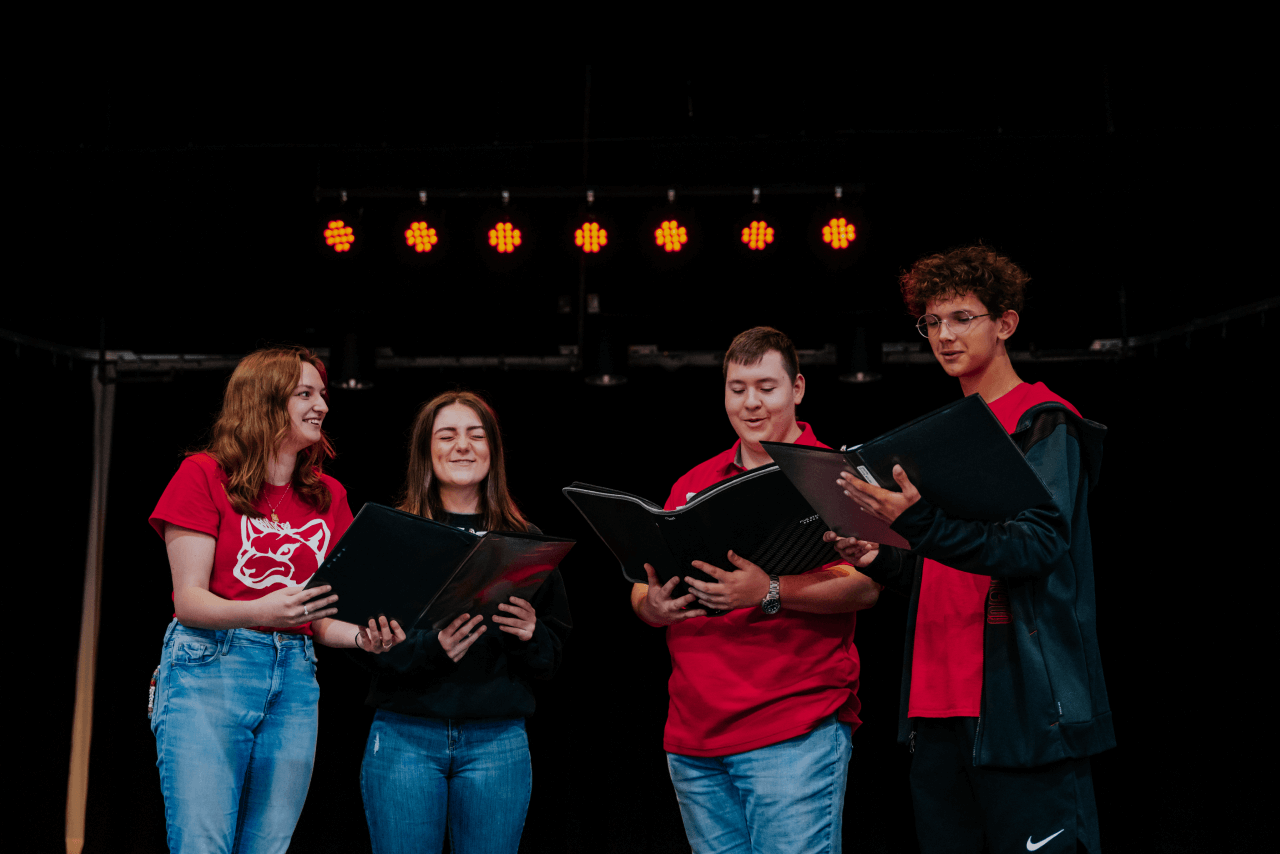 Group of four students singing in a choir